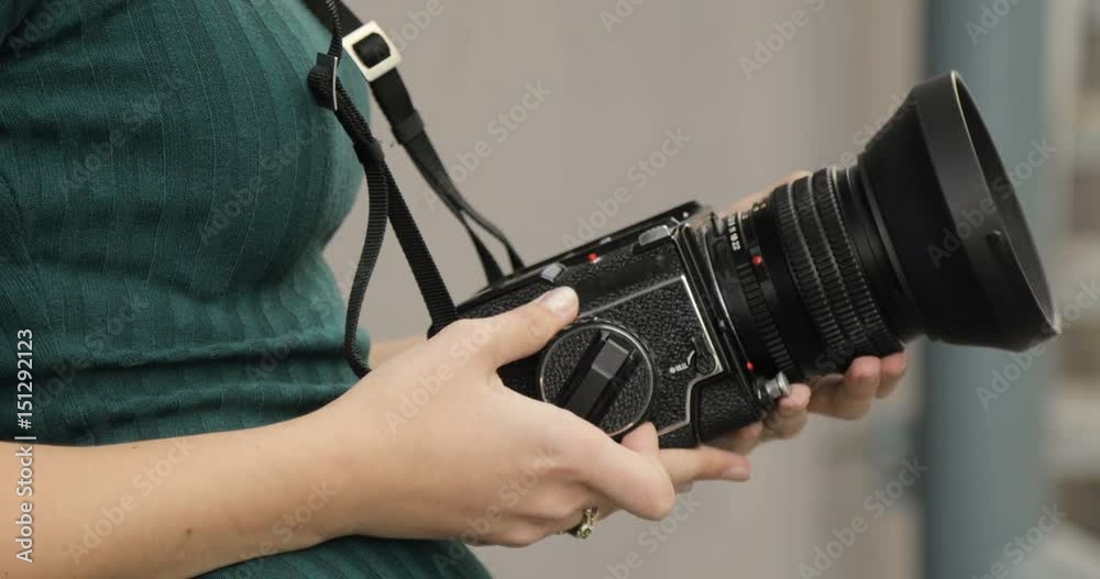 Old medium format camera in the hands of a hipster girl, close-up, film camera Old medium format camera in the hands of a hipster girl, close-up, film camera