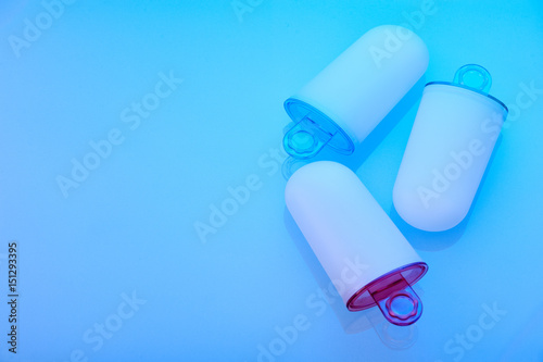 Ice cream molds lying on light blue surface, left space for text