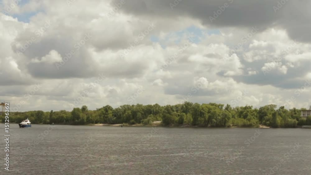 The sky is covered with clouds over a wide river The sky is covered with clouds over a wide river