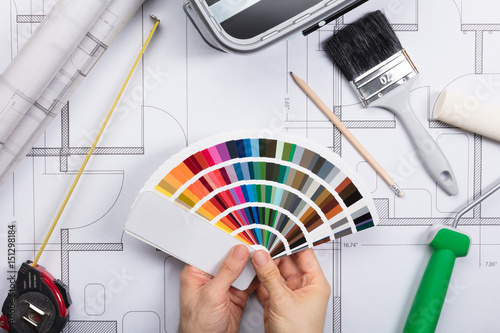 An Architect Holding Color Guide Swatch On Blueprints