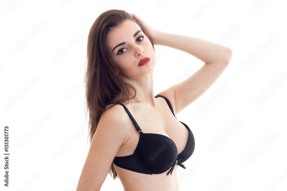 a charming young girl with red lipstick on lips and black brassiere with sexual breasts looks into a camera a charming young girl with red lipstick on lips and black brassiere with sexual breasts looks into a camera