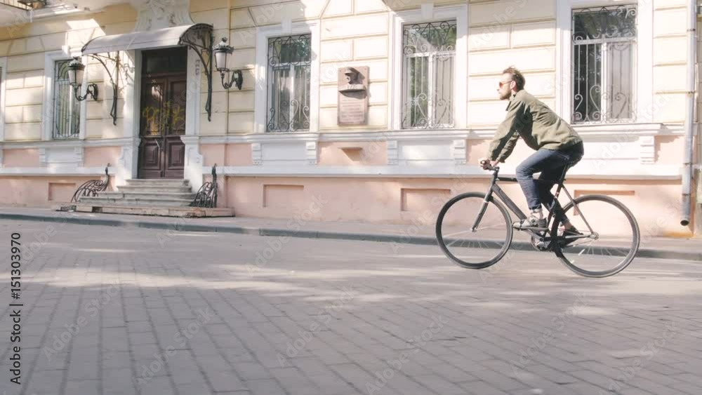Cyclist man riding fixed gear sport bike in sunny day on a city Cyclist man riding fixed gear sport bike in sunny day on a city