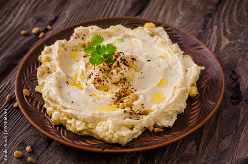 Plate of creamy hummus on wooden table.Ramadan food. Selective focus. Toned image