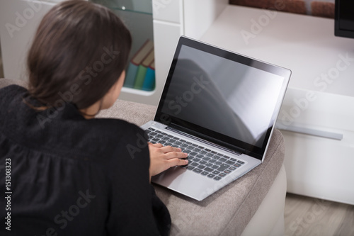 Rear View Of A Woman Using Laptop