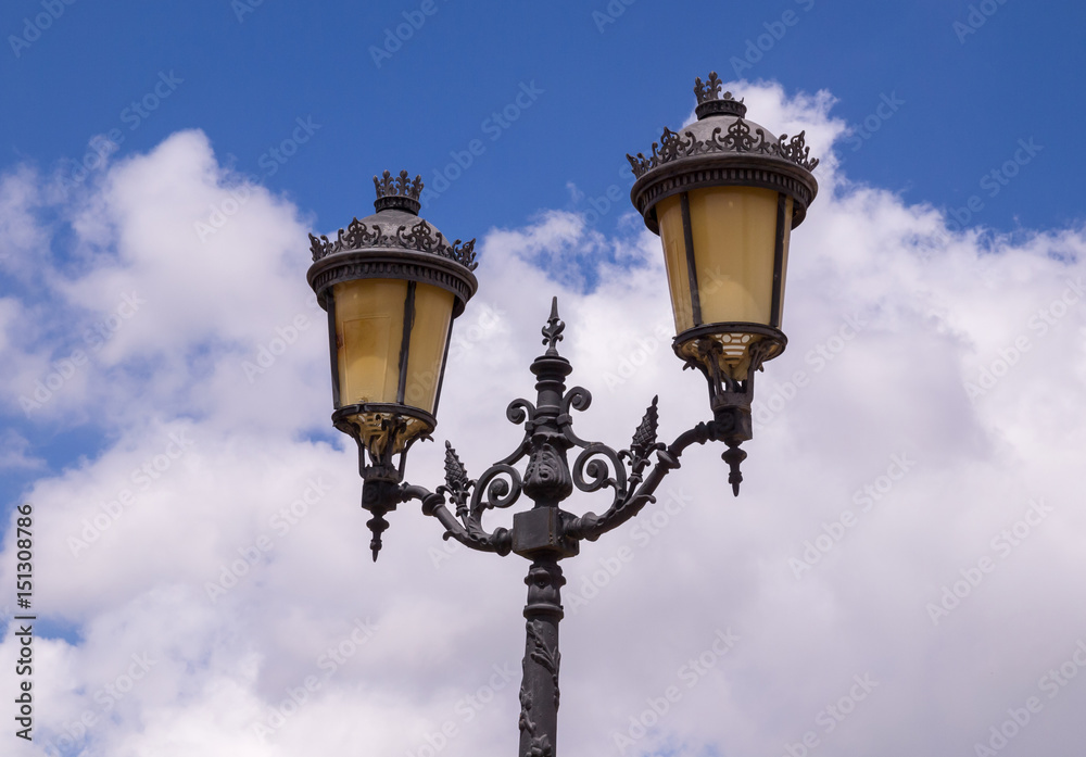 Old antique street lamp with blue sky with clouds