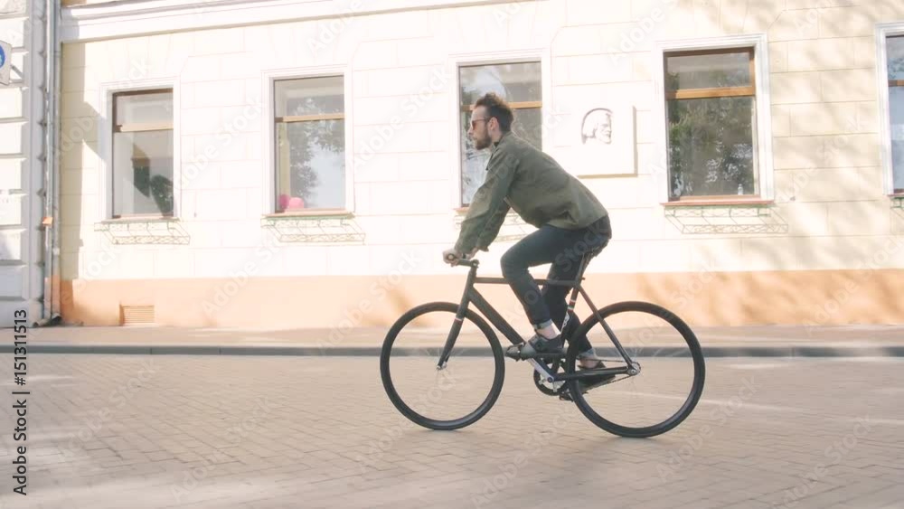 Cyclist man riding fixed gear sport bike in sunny day on a city Cyclist man riding fixed gear sport bike in sunny day on a city
