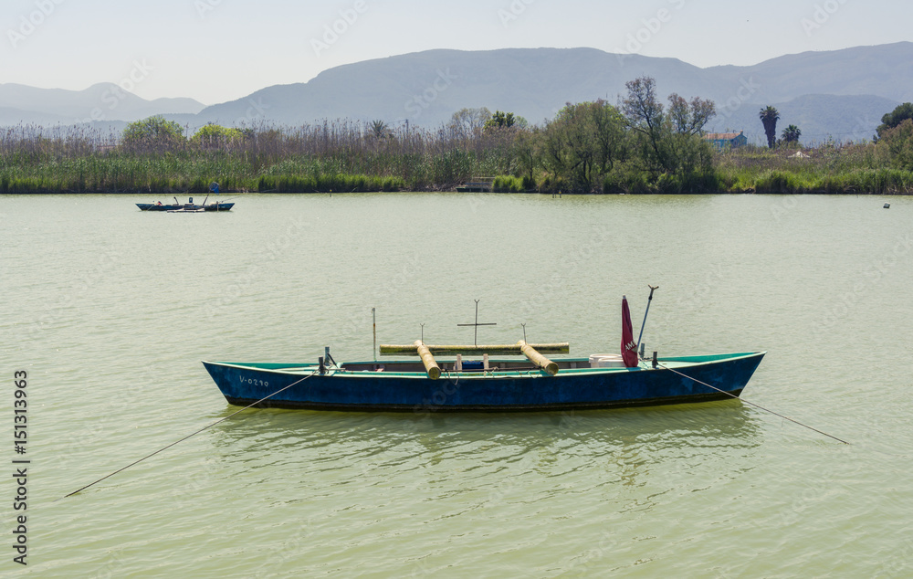 Calm lake with fishing boats. Fresh water lagoon in Estany de cullera. Valencia, Spain