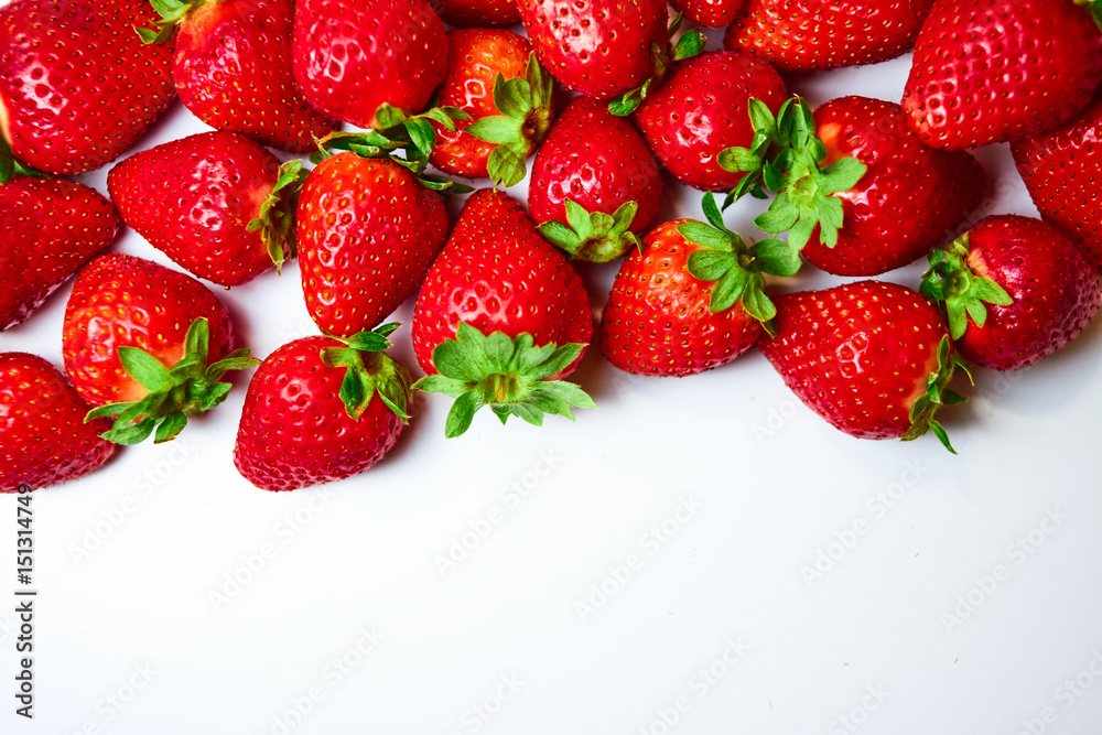 Berries of strawberries of different shapes and sizes are scattered randomly on a white background. Berries of strawberries of different shapes and sizes are scattered randomly on a white background.