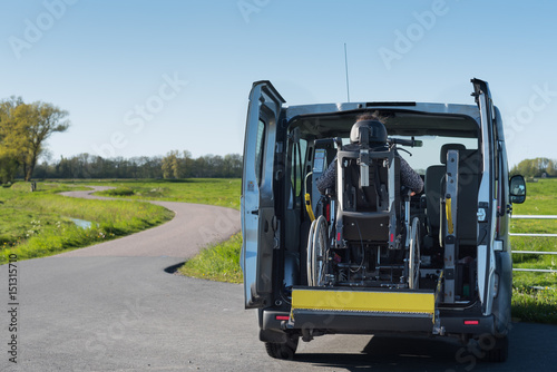 A disabled person being lifted into specially adapted vehicle