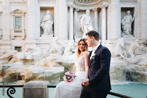 Bride and groom wedding poses in front of Trevi Fountain (Fontana di Trevi), Rome, Italy
