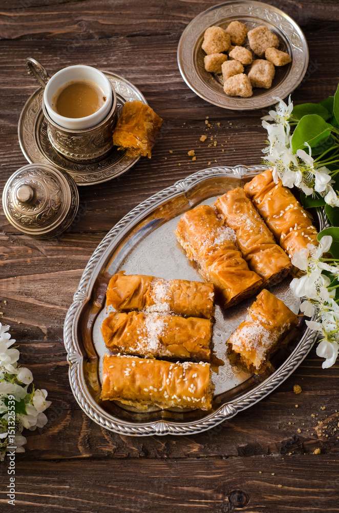 Homemade baklava rolls in iron try on wooden background. Ramadan food. Selective focus Homemade baklava rolls in iron try on wooden background. Ramadan food. Selective focus