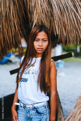 Portrait of a beautiful native Asian girl with the sunshade umbrella in the background