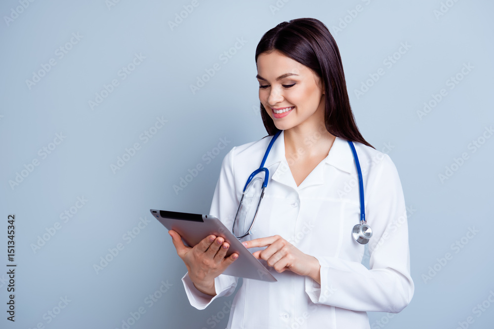 Portrait of pretty happy doctor using digital tablet and push touchscreen in her job Portrait of pretty happy doctor using digital tablet and push touchscreen in her job