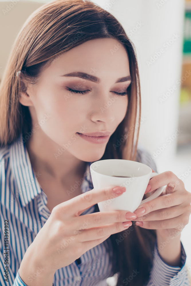Great beginning of the day. Relaxed dreamy business lady is resting at her work place and drinks coffeewith closed eyes Great beginning of the day. Relaxed dreamy business lady is resting at her work place and drinks coffeewith closed eyes