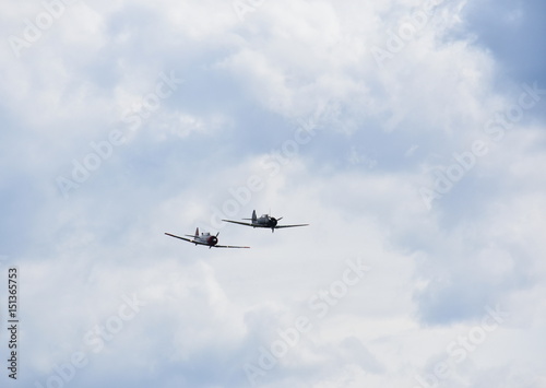 Airplane aerobatics  two airplanes flying together on an airshow.