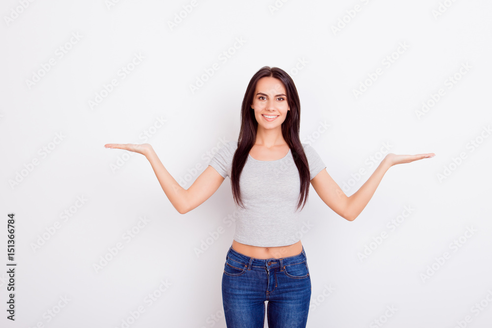 Cheerful charming girl in casual clothes on pure white background is gesturing with hands like she is holding something. Behind her is pure white copyspace Cheerful charming girl in casual clothes on pure white background is gesturing with hands like she is holding something. Behind her is pure white copyspace