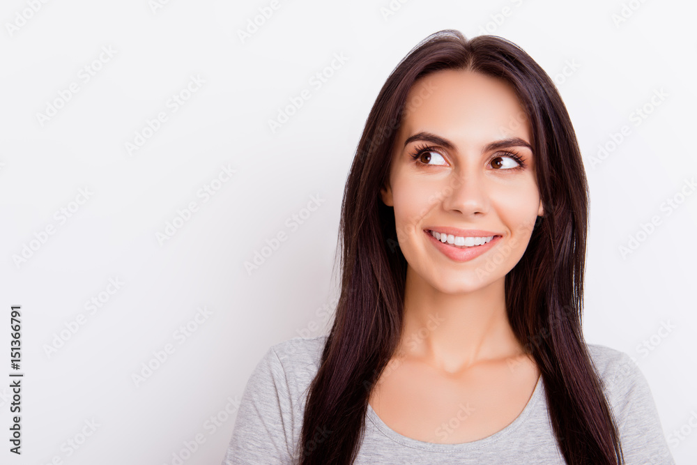 Close up portrait of young charming lady who looks away and ia dreaming of something, smiling on white background Close up portrait of young charming lady who looks away and ia dreaming of something, smiling on white background