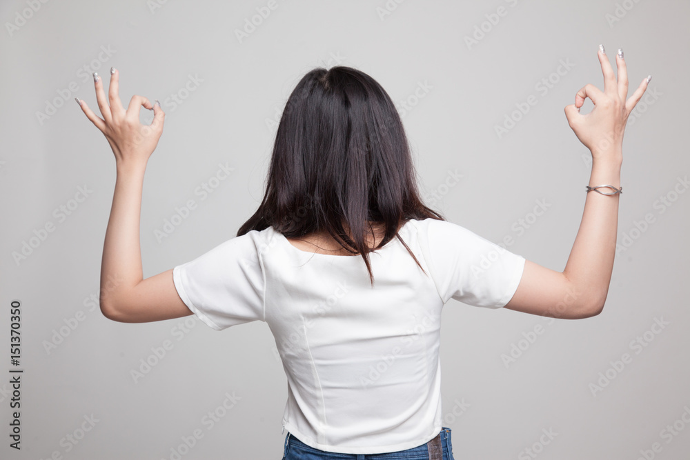 Fototapeta premium Back view of Asian woman show double OK hand sign.