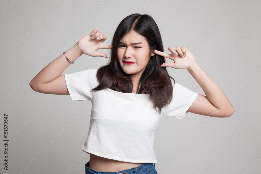 Young Asian woman block both ears with fingers. Young Asian woman block both ears with fingers.