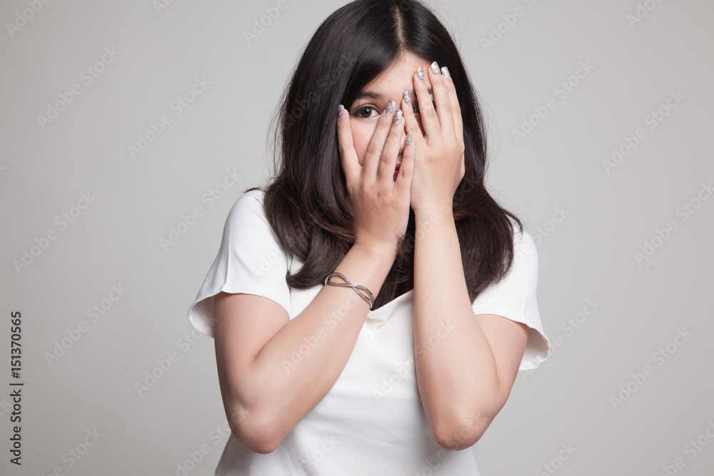 Beautiful young Asian woman peeking through fingers. Beautiful young Asian woman peeking through fingers.