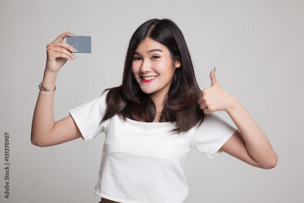 Young Asian woman thumbs up with a blank card. Young Asian woman thumbs up with a blank card.