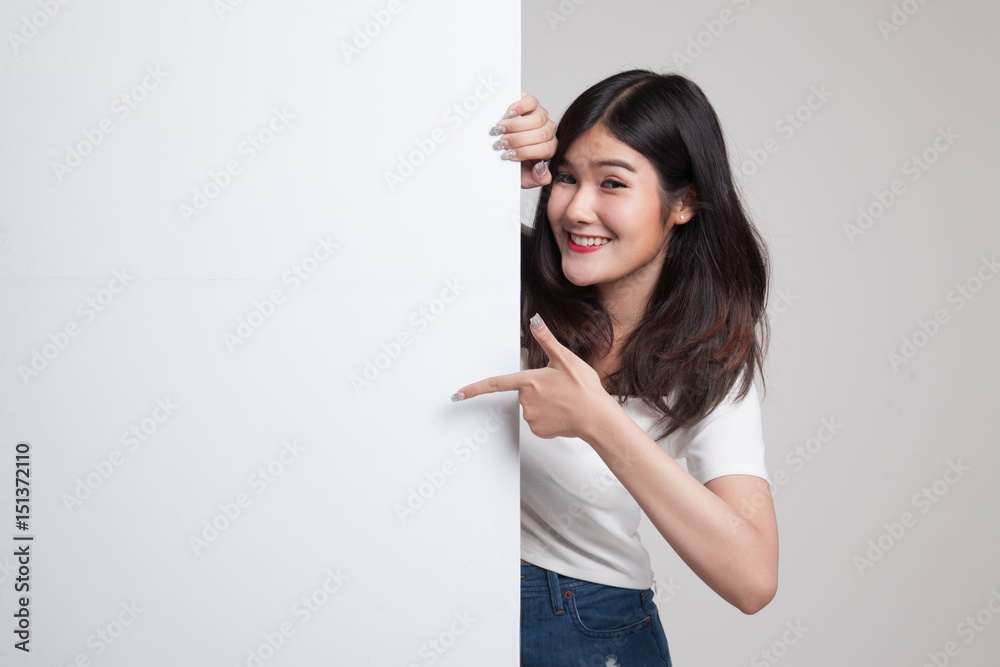 Young Asian woman point to a blank sign. Young Asian woman point to a blank sign.