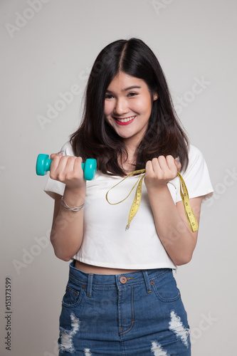 Healthy Asian woman with dumbbells and measuring tape.
