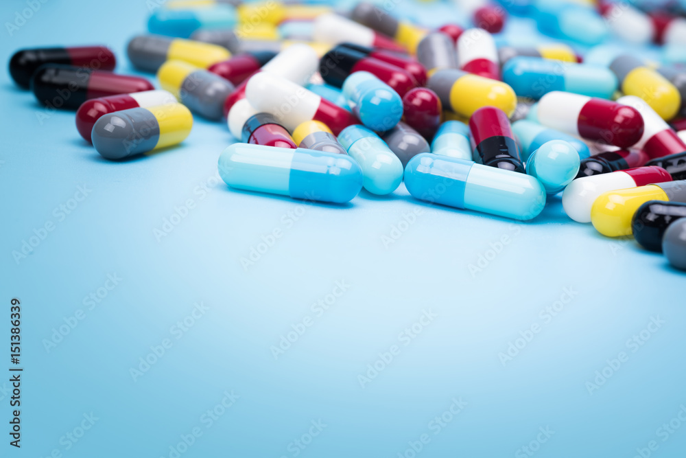 many scattered Colorful pills on blue background. many scattered Colorful pills on blue background.