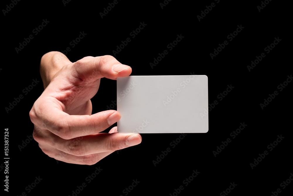 Male hand holding card on a black background. Male hand holding card on a black background.