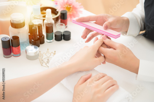 chinese manicurist is applying nail file