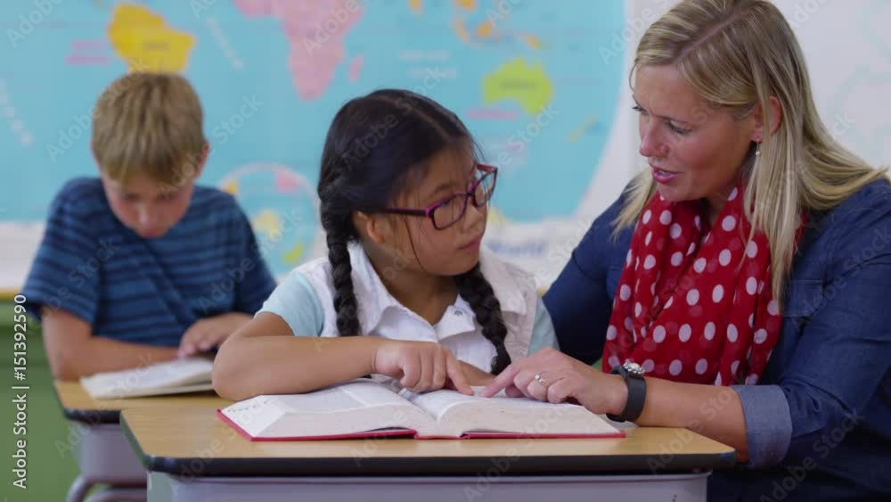 Teacher and student looking up word in dictionary together Teacher and student looking up word in dictionary together