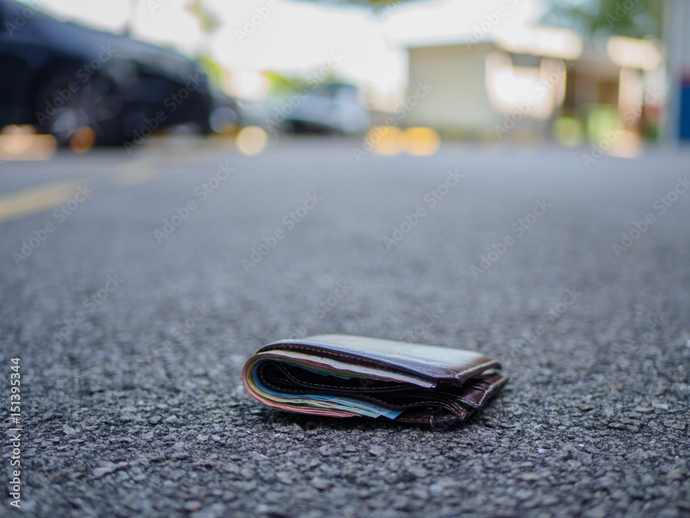 wallet with money drop on the street, lost money concept, copy space on top wallet with money drop on the street, lost money concept, copy space on top