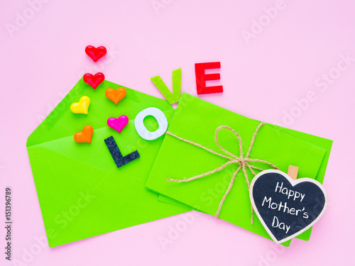 Happy Mother's day love letter concept. Opened envelope and many felt hearts. colorful of hearts with LOVE text on pink background.