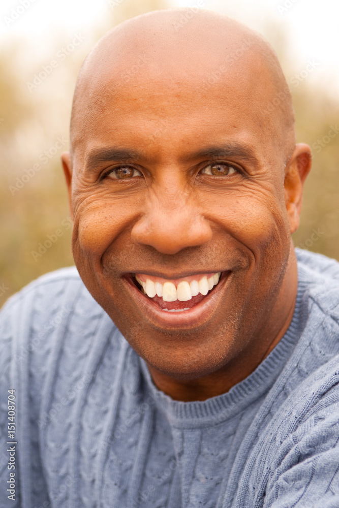 Mature African American man smiling sitting outside. Mature African American man smiling sitting outside.