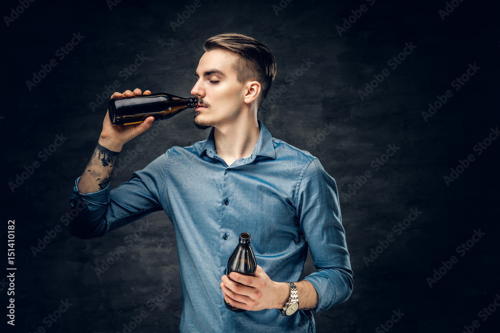 Fototapeta premium A man drinks craft bottled beer.