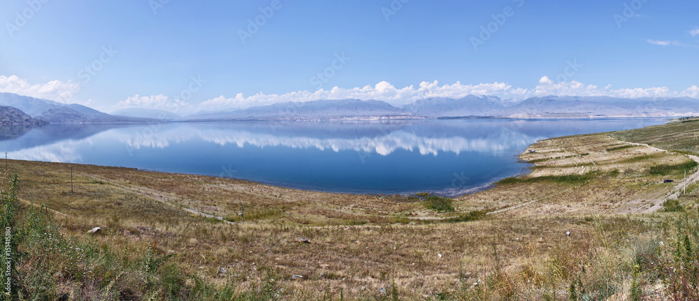 Kyrgyzstan, Toktogul lake. The road from Bishkek to Osh. Big mountain lake in Kyrgyzstan, blue, sunny weather, around the mountain.
