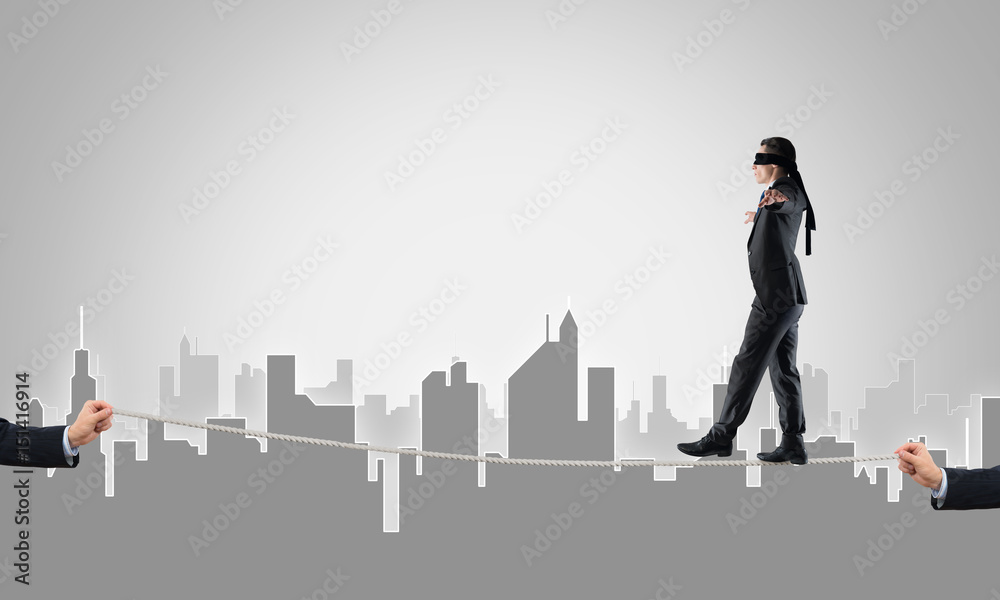 Business concept of risk support and assistance with man balancing on rope Business concept of risk support and assistance with man balancing on rope