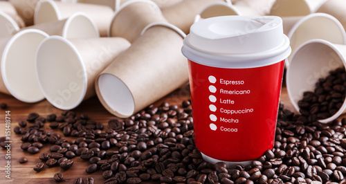 Red paper coffee cup with coffee beans and brown paper cups background
