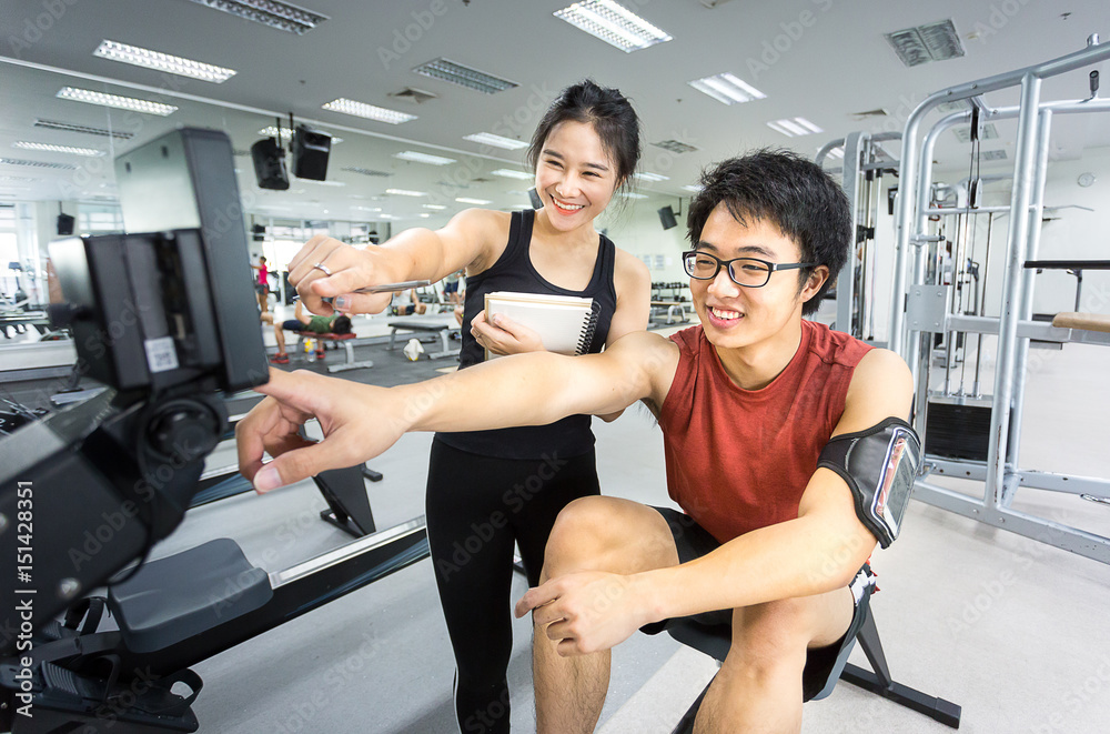 handsome young man play fitness machine with beauty teenage woma handsome young man play fitness machine with beauty teenage woma