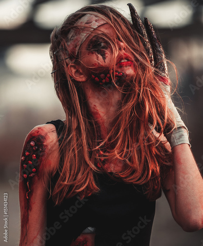 Photo Mutant girl portrait in wounds and ulcers with nails in her head and claws instead of fingers