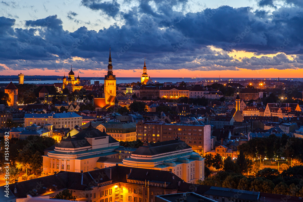 TALLINN, ESTONIA - JULY, 30, 2016: Orange sunset over old town. Cathedrals towers and modern buildings aerial view.