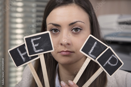 Business woman cheering for help, hiding behind the sign