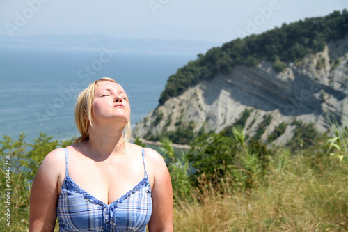 A young woman is enjoying the sunshine. It is a gorgeous day and she is sunbathing.