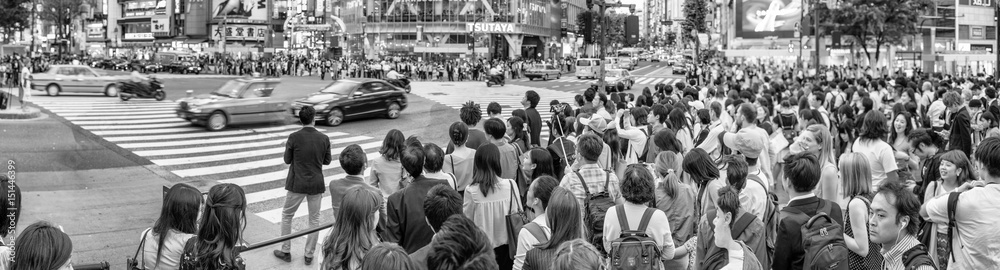 TOKYO - JUNE 1, 2016: Panoramic view of Shibuya Crossing with people at sunset. Shibuya is a popular district of Tokyo