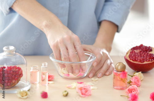 Woman making natural perfume with rose petals, closeup