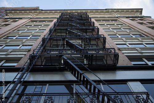 Canvas Print Dramatic Upward Skyward View, Tall City Building, Brick Front, Black Fire Escape