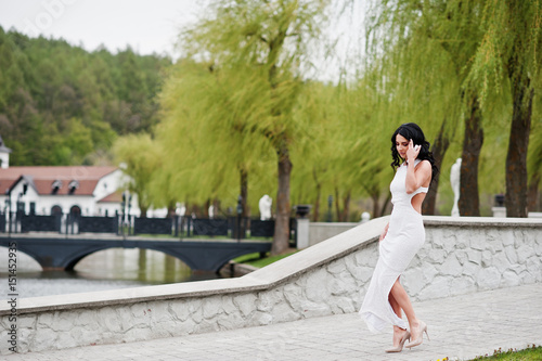 Young brunette elegant woman at white dress on ceremony wedding anniversary.