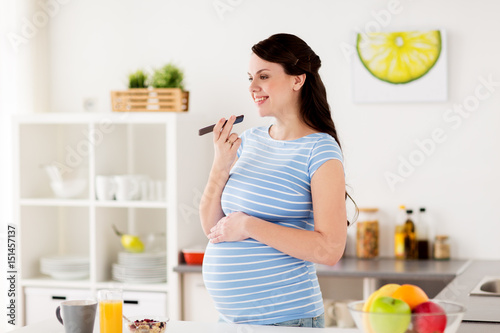 happy pregnant woman with smartphone at home