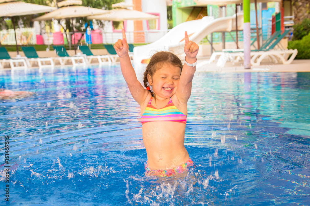 Naklejka premium A little child is dancing in the pool.