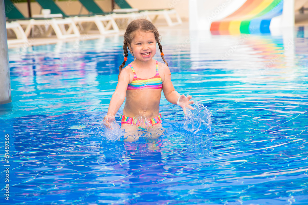 A little child is dancing in the pool.